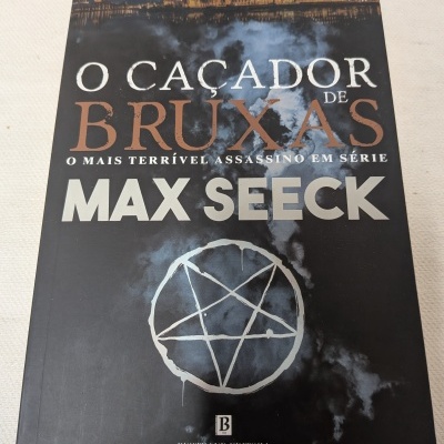 Livro O Caçador de Bruxas de Max Seeck com capa preta e pentagrama