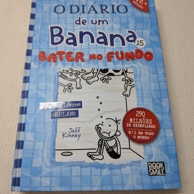 Livro infantil O Diário de um Banana 15 Bater no Fundo com capa azul e ilustração de personagem sentado.