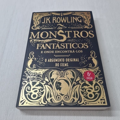 Capa de livro preto e dourado 'Monstros Fantásticos e Onde Encontrá-los' de J.K. Rowling