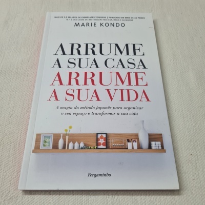 Livro ARRUME A SUA CASA ARRUME A SUA VIDA com imagem de prateleira e vasos