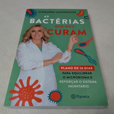 Capa de livro verde com título, imagem de mulher de jaleco e desenhos coloridos