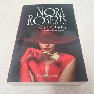 Livro 'Os O'Hurley' de Nora Roberts com capa mostrando mulher de vestido e chapéu vermelho segurando flor