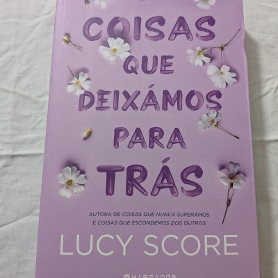 Capa lilás de livro com flores brancas e texto em roxo e branco