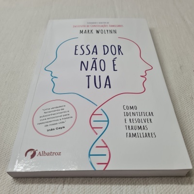 Livro 'Essa dor não é tua' com capa branca, ilustrações e texto em português