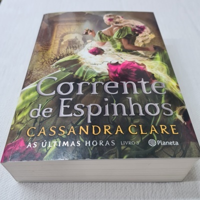 Livro 'Corrente de Espinhos' de Cassandra Clare com capa de mulher em vestido verde e rosas vermelhas