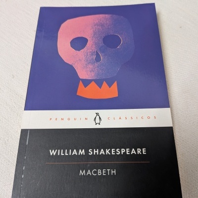 Capa do livro Macbeth de William Shakespeare, edição Penguin Clássicos, com ilustração de crânio rosa e coroa laranja.
