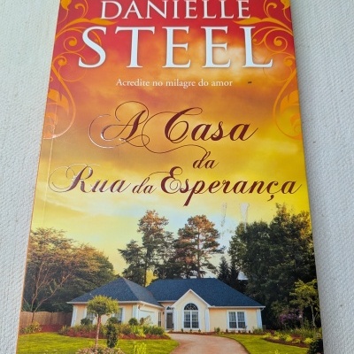 Capa do livro A Casa da Rua da Esperança de Danielle Steel com imagem de uma casa e céu colorido.