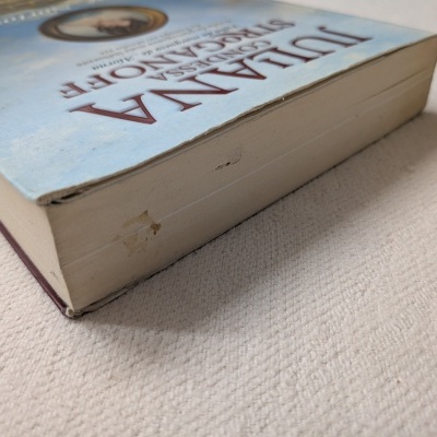 Livro JULIANA CONDESSA DE ROCANOTTE com capa azul e bordas das páginas gastas e manchadas