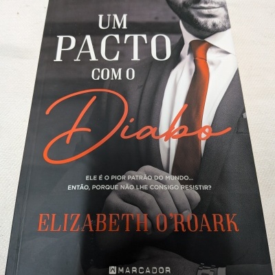 Capa de livro Um Pacto Com O Diabo com homem de fato cinzento e gravata vermelha