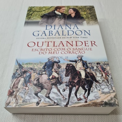 Livro Outlander Vol. II com ilustração de cavalaria histórica na capa