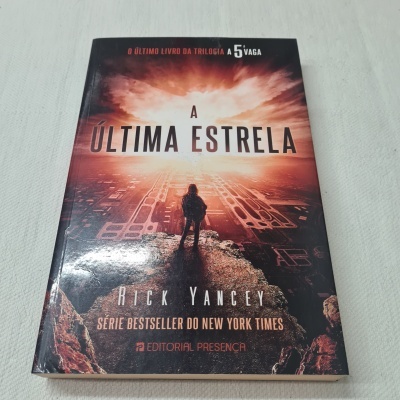 Livro 'A Última Estrela' com capa com figura e tons laranja e preto
