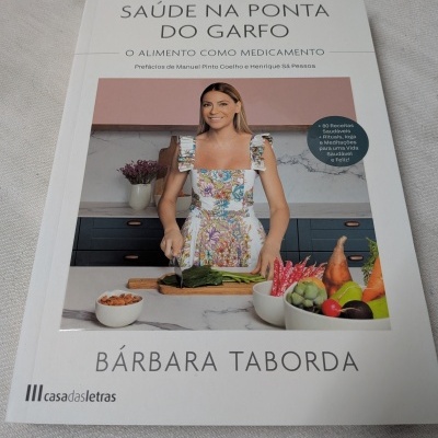 Capa do livro de receitas e saúde com imagem de uma mulher a cortar legumes na cozinha