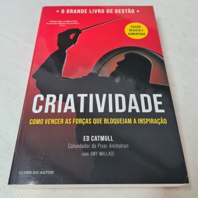 Capa de livro vermelho e preto com título CRIATIVIDADE e imagem de sombra de pessoa com um bastão.