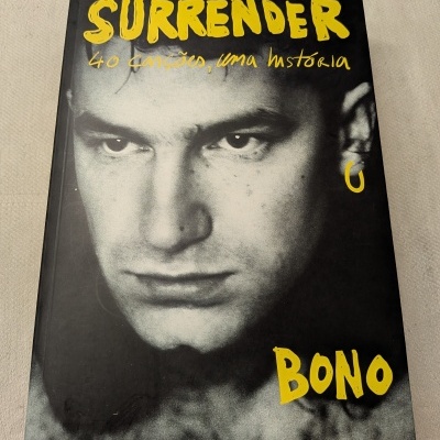 Capa de livro mostrando um rosto masculino em preto e branco com texto amarelo.