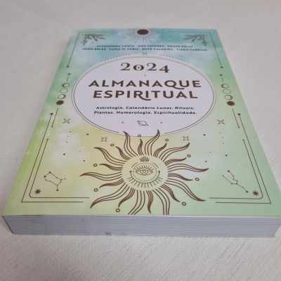 Livro com capa verde e amarelo e detalhes solares e constelações