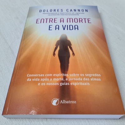 Capa de livro 'Entre a Morte e a Vida' de Dolores Cannon com figura humana e luz