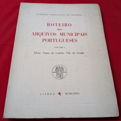 Livro Roteiro dos Arquivos Municipais Portugueses com capa branca sobre fundo vermelho