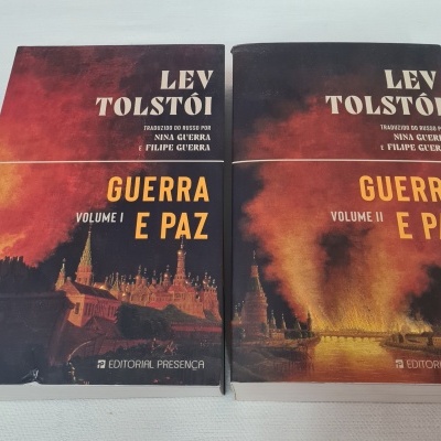 Dois livros Guerra e Paz de Lev Tolstói com capas em tons escuros e cenas de cidade em chamas