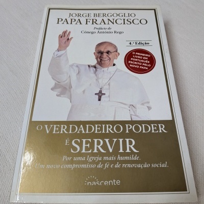 Livro O verdadeiro poder é servir de Papa Francisco sobre superfície têxtil clara
