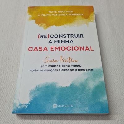 Livro com capa branca e manchas amarelas e azuis, texto colorido