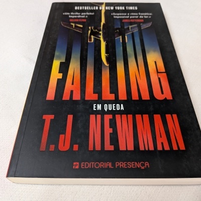 Capa do livro Falling em preto com letras laranja e vermelho.