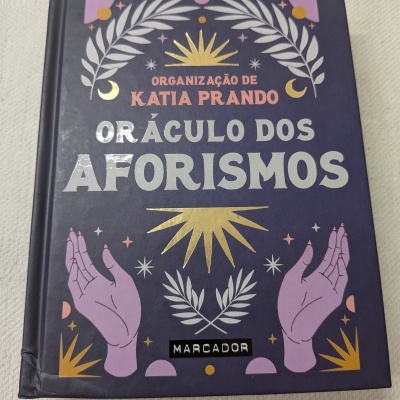 Capa de livro roxa com título e ilustrações em dourado e lilás
