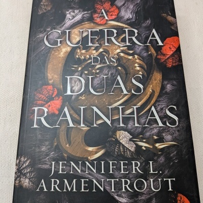 Capa do livro A Guerra das Duas Rainhas com fundo preto e detalhes dourados e vermelhos