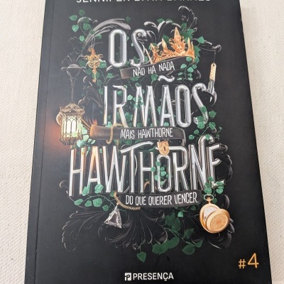 Capa de livro preto com título e ilustrações douradas e verdes