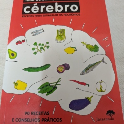 Capa de livro vermelho com ilustração de cérebro formando por legumes e texto sobre receitas para estimular neurónios.