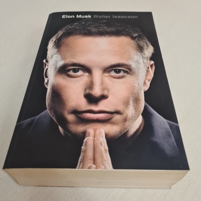 Capa frontal do livro 'Elon Musk Winter Isaacson' com foto de Elon Musk e fundo preto