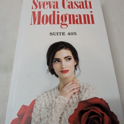 Capa de revista com texto e mulher em vestido branco com rosa vermelha