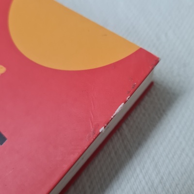 Canto danificado de embalagem vermelha e laranja