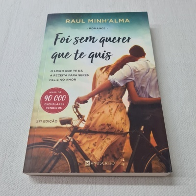 Capa de livro com casal abraçado ao lado de bicicleta e textos promocionais