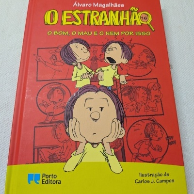 Livro O Estranhão com capa vermelha e amarela e ilustrações