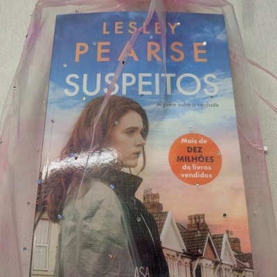 Livro Suspeitos de Lesley Pearse com tecido rosa translúcido com brilhantes