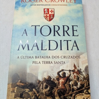 Livro com capa ilustrada mostrando cavaleiros medievais e título A Torre Maldita