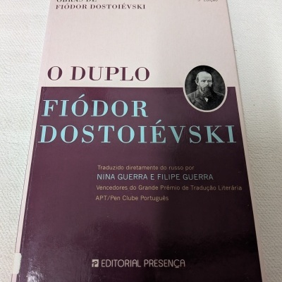 Livro O Duplo de Fiódor Dostoiévski com capa rosa e vinho e fotografia do autor