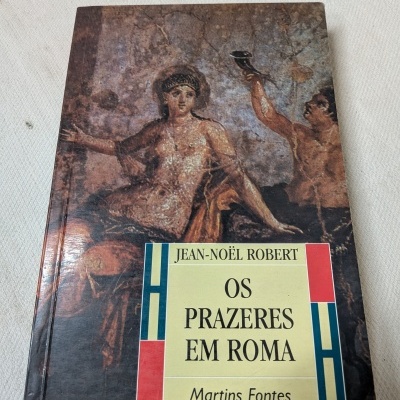 Capa de livro com pintura clássica e título Os Prazeres em Roma