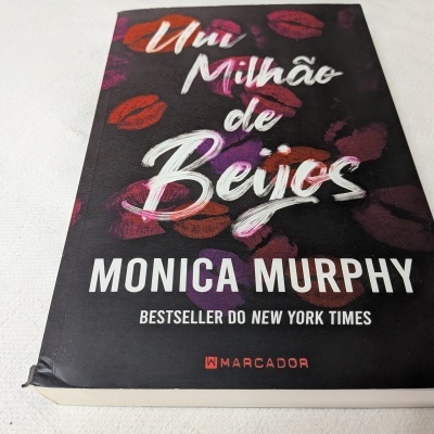 Capa do livro 'Um Milhão de Beijos' de Monica Murphy com estampas de lábios coloridos