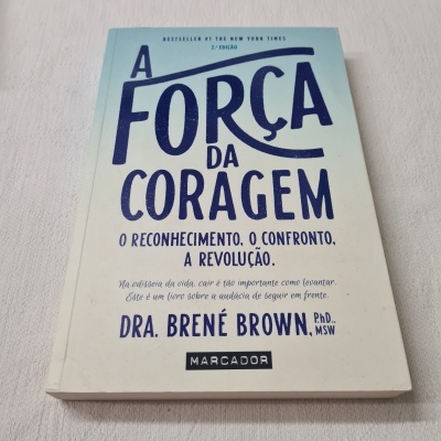 Livro A FORÇA DA CORAGEM de Dra. Brené Brown sobre superfície cinza clara