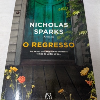 Capa de livro O REGRESSO com porta verde e flores ao redor
