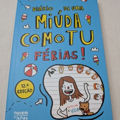 Capa de livro infantil azul com título amarelo e vermelho e desenho de rapariga e cão