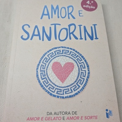 Capa do livro Amor e Santorini com texto azul e rosa e coração de mosaicos.