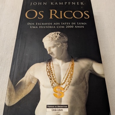 Capa do livro Os Ricos com estátua e colares dourados
