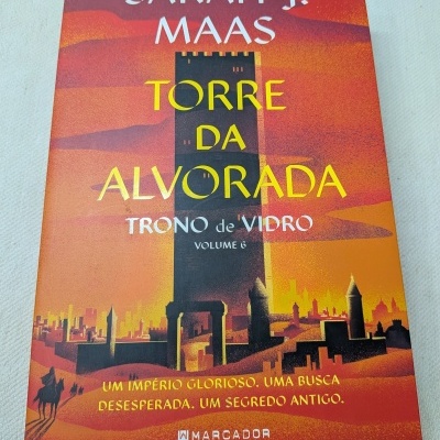 Capa do livro Torre da Alvorada de Sarah J. Maas com ilustração de torre e fundo em tons quentes.