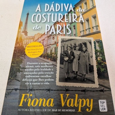 Capa do livro A Dádiva da Costureira de Paris de Fiona Valpy com fotografia de mulheres antigas e rua parisiense colorida