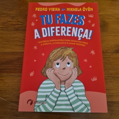 Capa de livro infantil vermelha com ilustração de criança e texto 'TU FAZES A DIFERENÇA!'
