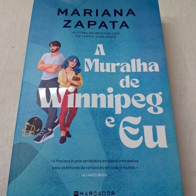 Capa do livro azul A Muralha de Winnipeg e Eu de Mariana Zapata com ilustração de homem, mulher e capacete de futebol americano