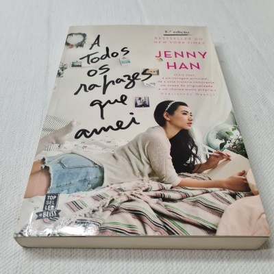 Capa do livro 'A todos os rapazes que amei' de Jenny Han com imagem de jovem deitada debruçada