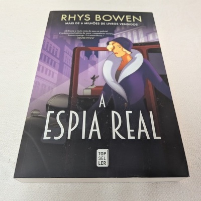 Capa do livro A ESPIA REAL de Rhys Bowen com ilustração de mulher a sair de carro